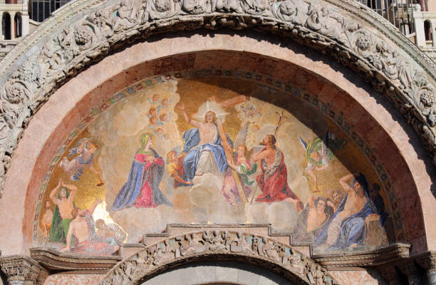Venice, Veneto, Italy: western façade lunette with a Byzantine mosaic depicting Christ's resurrection and ascension to heaven, framed by phrases from St Mark's gospel.