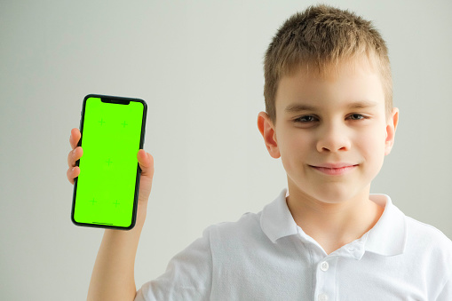 Boy holding phone with green screen