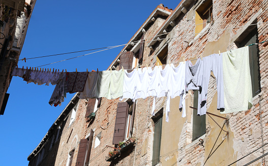 clothes hung out to dry in the sun among the old houses of the European city in the summer