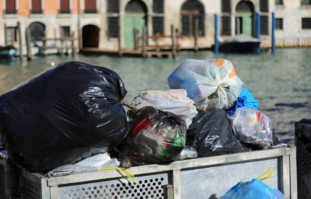 three garbage baskets, one for general waste, the other two for recyclables, in a park in Venice, Italy