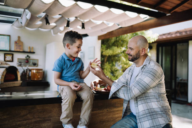 istock Dad and son eating apple outdoors in the patio 2089390912