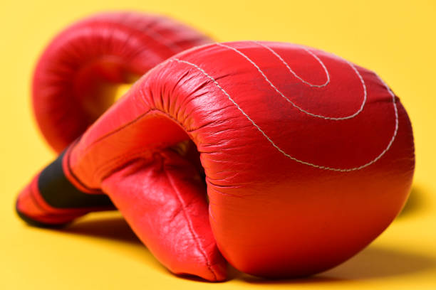 Two red boxing gloves and black bagground.