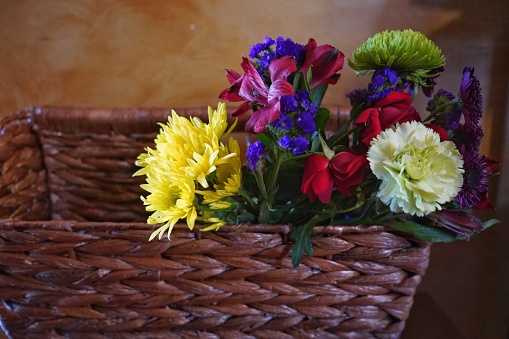 Bouquet of Lilies of the Valley in a basket isolated on wooden background