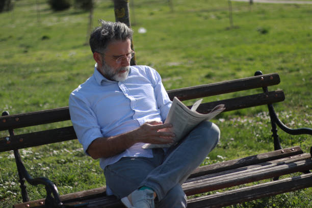 istock Mature man read newspaper in public park 2089458129