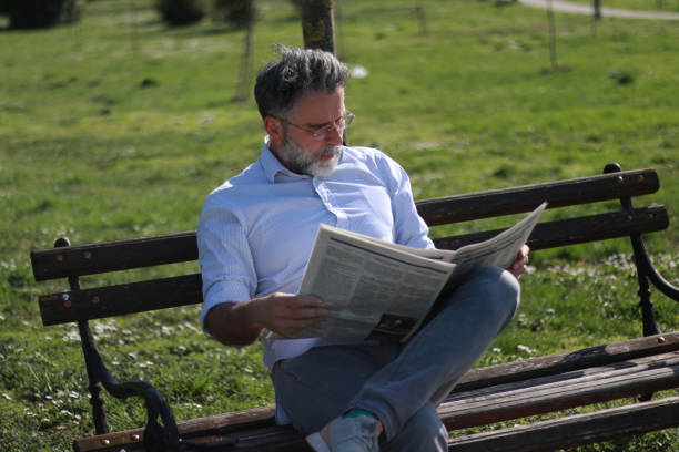 istock Mature man read newspaper in public park 2089458633