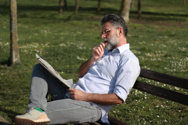 istock Mature man read newspaper in public park 2089458870