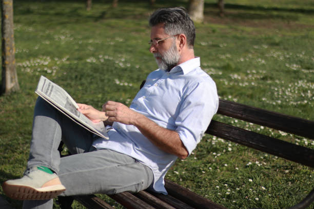 istock Mature man read newspaper in public park 2089459150