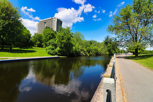 Spokane River and Riverfront Park with beautiful early morning reflections.. Lined with wispy willow trees at water's edge. Perfoming Arts Center and Clock Tower in park. Heritage buildings in background.