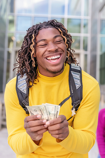 Young  student holding money smiling