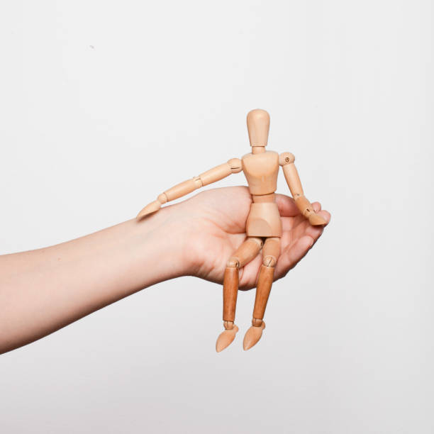 istock Support. A parent who provides support, attention, security to his child. Psychotherapy for adolescents. A hand holding a wooden mannequin in its palm. 2089525100