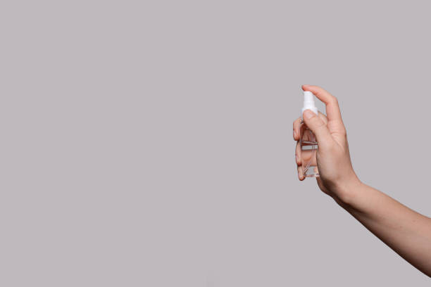 istock Female hands using hand sanitizer spray dispenser over light grey background 2089525104