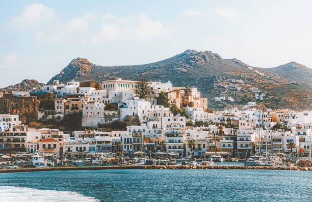 Cityscape view of Naxos City, where whitewashed buildings adorned with colorful windows stand proudly against the backdrop of the sparkling Mediterranean sun. The waterfront glistens with a captivating radiance, inviting residents and visitors alike to bask in its beauty. With its charming streets and vibrant atmosphere, Naxos City offers a delightful variety of experiences, from leisurely strolls along the promenade to exploring the bustling markets and quaint cafes. This coastal gem captivates the heart without the need for words, leaving a lasting impression on all who behold its splendor.