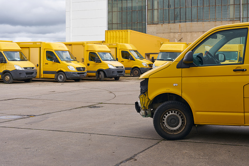 Magdeburg, Germany – March 16, 2024: Discarded DHL vehicles that are no longer roadworthy in the yard of a car recycler in Magdeburg, Germany