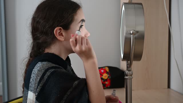 Teenager girl putting mascara on eyebrows