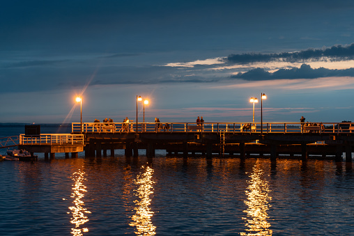 night molo pier with lantern yellow light at Polish village Jastarnia, sunset. High quality photo