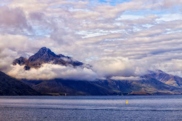 Cecil peak over Wakatipu lake in New Zealand from Queenstown bay beach.
