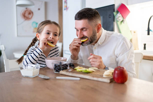 istock Daughter and father having slice of lemon for an breakfast 2089628352