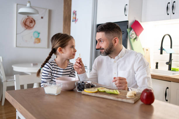 istock Caucasian father with daughter sharing banana for breakfast 2089631498