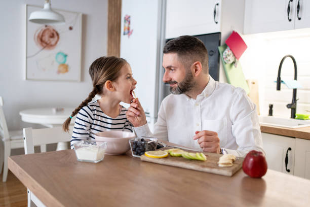 istock Caucasian father with daughter sharing banana for breakfast 2089633047