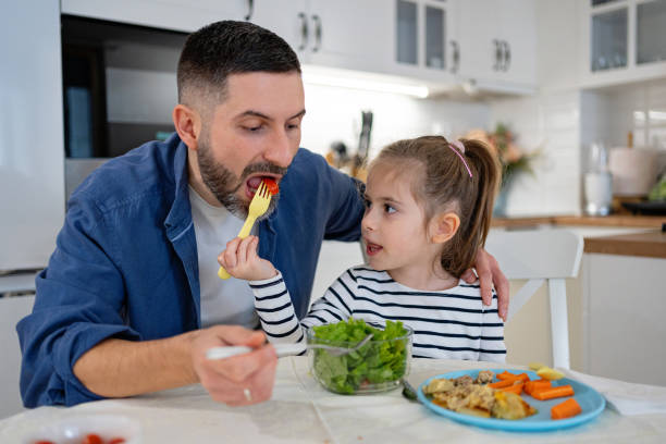 istock Caucasian father feeding daughter with carrot, for an luncha 2089643486