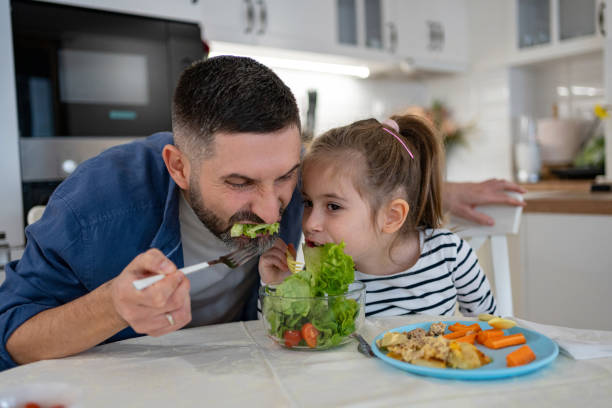 istock Caucasian father and daughter sharing an salad for a lunch 2089643489