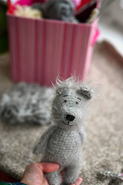 istock Woman's hand holding crocheted teddy bear. 2089686776
