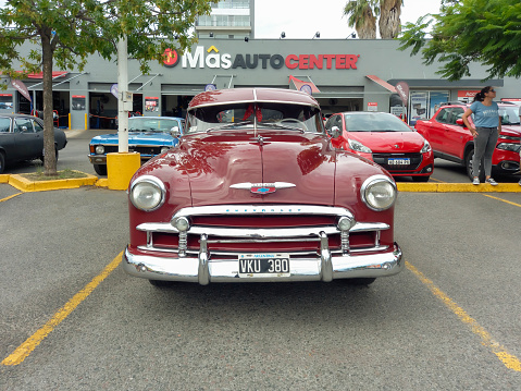 Buenos Aires, Argentina - Feb 25, 2024: Old red shiny 1949 Chevrolet Styleline two door sedan at a classic car show in a parking lot. Front view. Copy space