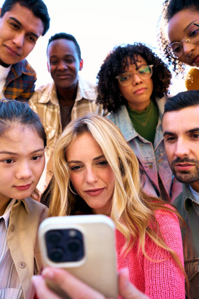 istock A group of happy amazed humans friends in outerwear using mobile smiling watching something funny 2089795471
