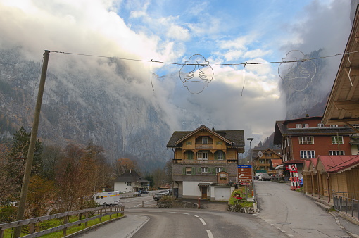 Tourist area on a cold day and in the background the Lauterbrunnen valley covered by clouds with blue sky opening, Lauterbrunnen, Switzerland - December 1, 2022