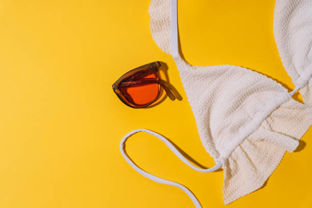 istock White swimsuit bra with folding sunglasses on yellow background 2089901887