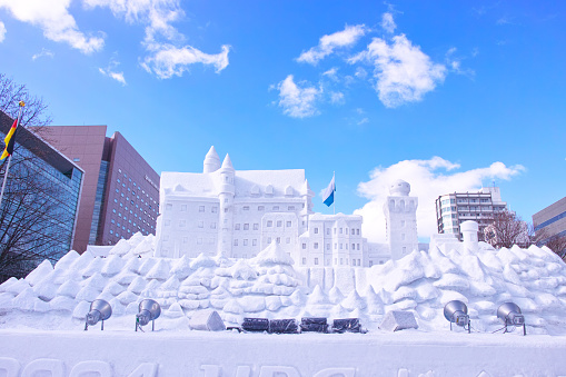 Sapporo, Hokkaido, Japan - February 9, 2024: Sapporo Snow Festival with blue sky visible, snow sculpture of Germany's Neuschwanstein Castle seen from the front.