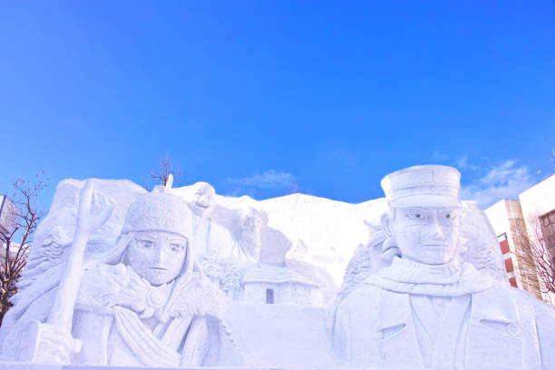 Sapporo, Hokkaido, Japan - February 9, 2024: Golden Kamuy character snow statues at the Sapporo Snow Festival with blue skies visible.