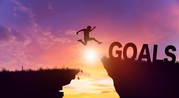istock Silhouette man jumping form cliff to another mountain with Goals. 2090003878