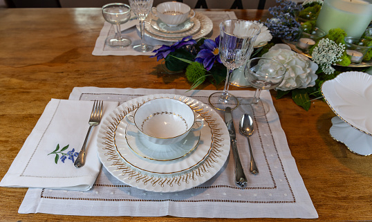 Gold and white fine porcelain place setting with crystal etched in gold on an Easter table.