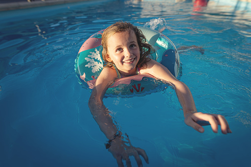 Little girl in an inflatable ring in the swimming pool