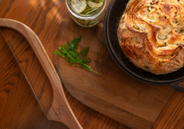 istock Sourdough bread on a cast iron dutch oven lid garnished with pickles and dill, next to a bread knife 2090013201
