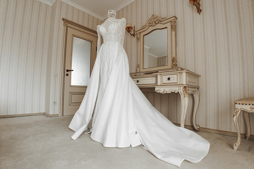 wedding dress in the interior of the hotel, prepared for the ceremony. Wedding dress with sleeves and closed shoulders