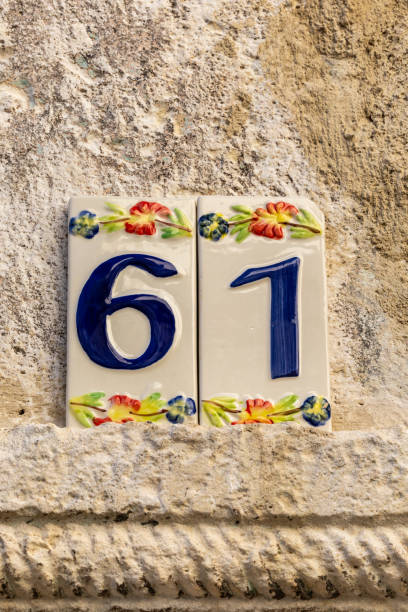 Goriano Sicoli, Italy An ornate 61 house number on the facade of a house.