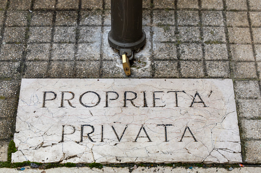 Scanno, Italy A marble sign in the sidewalk says Private property in Italian.
