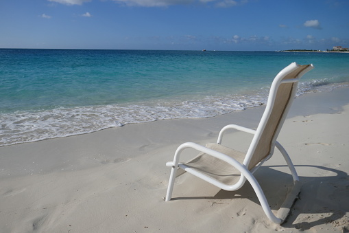 Tranquil scene with beach chair and clear ocean in background