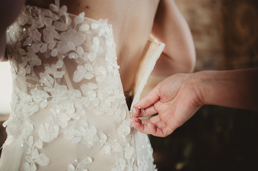 Bride getting into her wedding dress on her wedding day