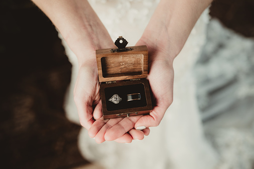 Bride holding wedding rings in a jewelry box in her hands