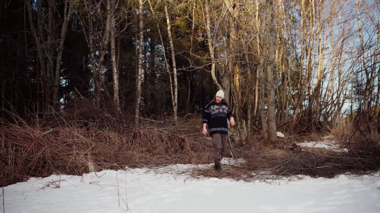 The Man is Throwing the Kindling Off to the Side of the Forest for Use as Firewood During the Winter Season in Indre Fosen, Trondelag County, Norway - Static Shot