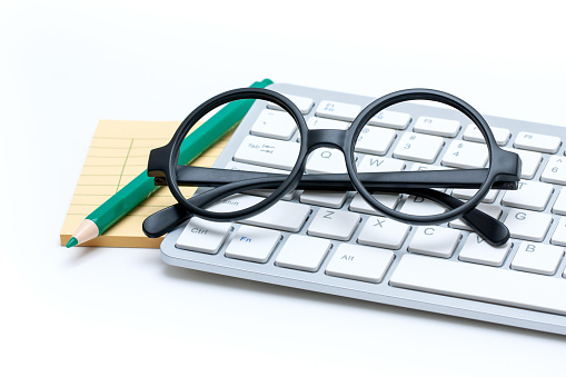 Glasses and keyboard isolated on white background.