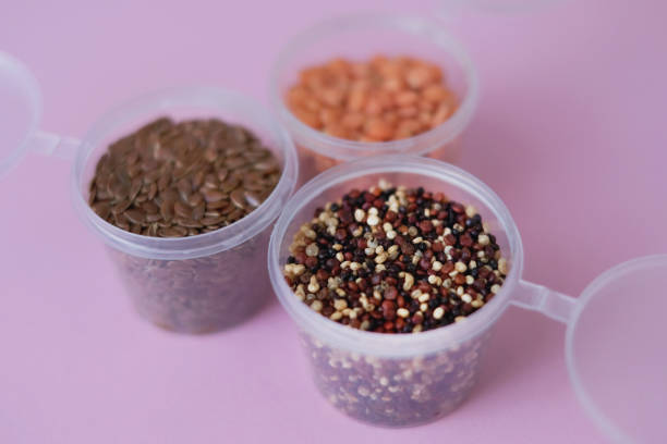 High angle shot of variation superfood seeds in small plastic cups. There's quinoa , red lentil and  flax seeds