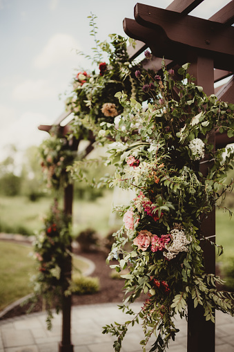 Outdoor wedding ceremony arch with roses and flowers