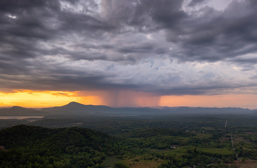 Aerial view of rain storms and black clouds moving over mountains. Huge black rain clouds and rainstorms fell on the forested mountain areas in northern Thailand.