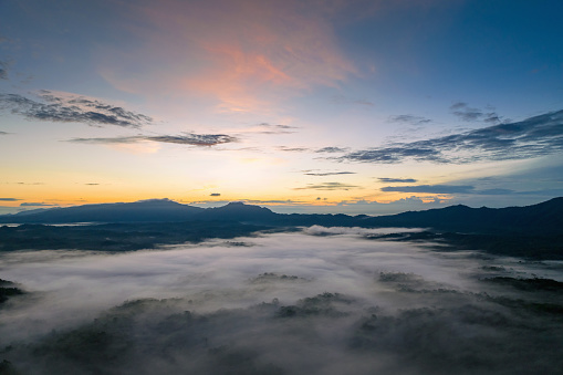 Landscape view of dawn, golden light, sun rise, and mist flowing through the high mountain forest in Mae Moh, Lampang.