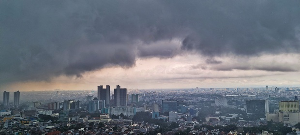Jakarta, Indonesia - Mar 17, 2024: Aerial landscape picture of dark cloud and raining area in Jakarta