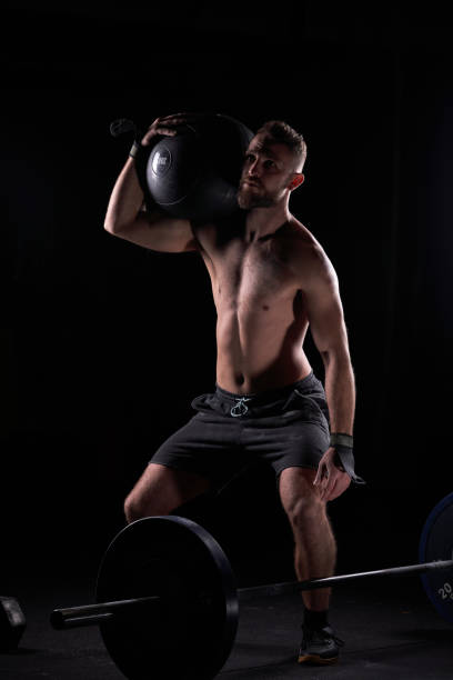 istock Strong sportsman with weight ball on shoulder performing exercis 2090592929